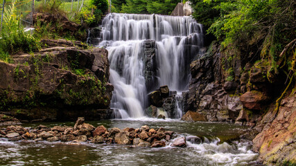 Fototapeta na wymiar Two level waterfall flowing gracefully over rocks