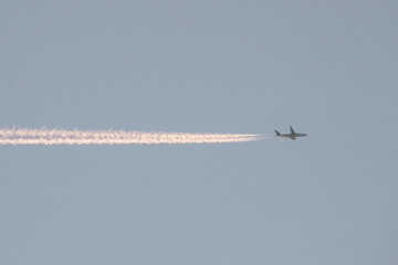the plane flying across the sky with jet trail