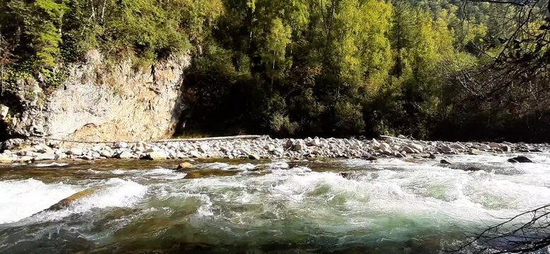 Fast mountain river with stones and foam on the water. River rapids