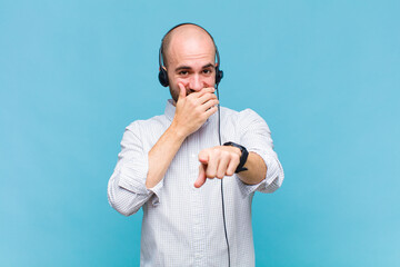 bald man laughing at you, pointing to camera and making fun of or mocking you