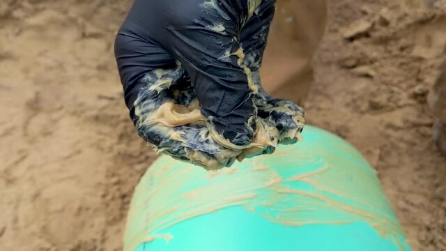 Construction worker wearing nitrile gloves rubbing and squishing pipe lube / grease between their fingers.  Slow Motion.