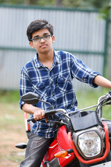 Obraz premium Indian young boy sitting on a motorcycle