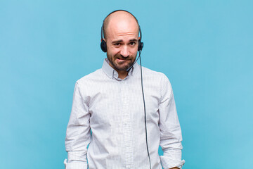 bald man looking puzzled and confused, biting lip with a nervous gesture, not knowing the answer to...