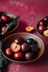 Red plums in a bowl summer food flatlay
