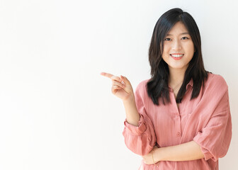 Beautiful cheerful woman standing by a white wall