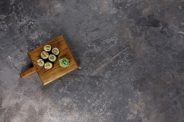 Obraz premium Appetizing rolls on a textured background. Japanese food concept. Close-up. Copy space. Flat lay.