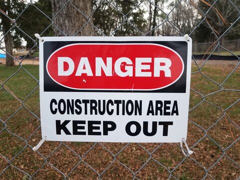 danger construction area keep out sign on fence