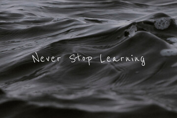 Never stop learning quote on a water wave background