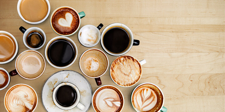 Assorted coffee cups on a light brown wooden board © Rawpixel.com