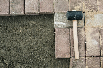 mallet lies on the sidewalk stone top view. laying of paving slabs.