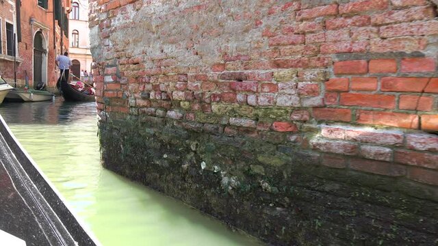 Gondolas going in canals in Venice Italy. Gondola is a traditional, flat-bottomed Venetian rowing boat, well suited to the conditions of the Venetian lagoon. It is similar to a canoe. It is propelled 