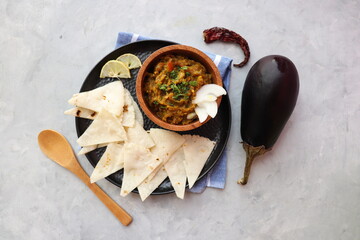 Baigan Bharta, also called Vangyache Bharit in Marathi. It is a roasted eggplant curry. Brinjal chutney. served in a wooden bowl with rice roti or tandalachi bhakri. copy space.