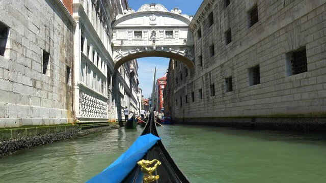 Gondolas going in canals in Venice Italy. Gondola is a traditional, flat-bottomed Venetian rowing boat, well suited to the conditions of the Venetian lagoon. It is similar to a canoe. It is propelled 