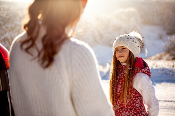Mother and daughter communicate on the nature in winter holiday. People spending time together with family