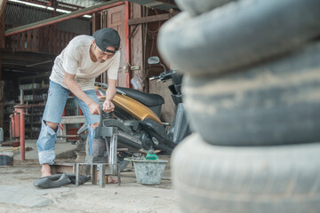 Tire patcher prepares a traditional press before patching the inner tube in a motorcycle repair shop