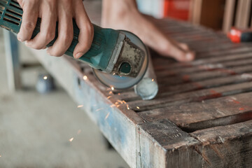 close up of mechanical hands using grinding machines to smooth the surface of the iron rods in the workshop