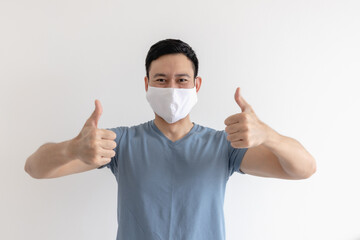 Happy and pleased expression of Asian man in white mask on isolated background.