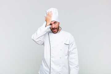 bald man raising palm to forehead thinking oops, after making a stupid mistake or remembering,...