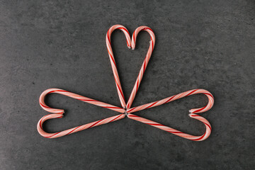 Group of Christmas Candy Canes In Heart Pattern On Dark Slate