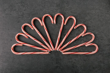 Group of Christmas Candy Canes In Heart Pattern On Dark Slate