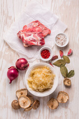 Ingredients for hearty sour cabbage soup (sauerkraut soup) with meat, onioc, garlic and spicies