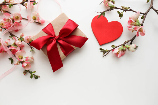 happy valentine's day card mockup. romantic composition of a blossoming branch, a gift box and a red heart