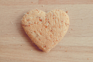 Grained bread cut off as heart shape. Concept of love and care in Valentine day.
