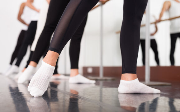 Legs of ballet dancers, near the choreographic training machine.