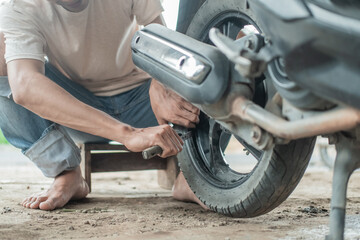 Tire Repairman uses a tire scraping tool to remove motorcycle tires in a tire repair shop