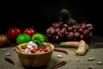 Low light photography spicy Thai food curry called Tom yum kung