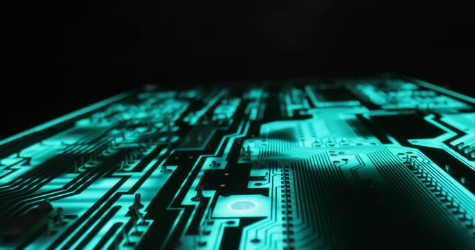 Electronics computer circuit board macro glowing in blue light, slider macro shot