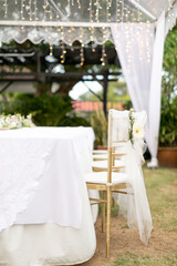 Fototapeta na wymiar gold chiavari chair decorate with a flower on a wedding day