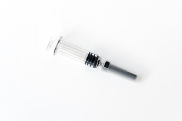A syringe with a needle and a cap for medical vaccination on a light background lies on the table. copy space. flatlay.