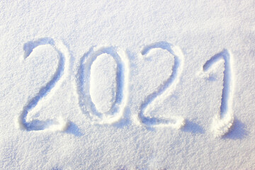 Happy new year 2021 sign text written with numbers from snow on snow surface, symbol of the next...