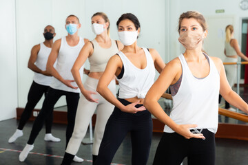 Fototapeta na wymiar Ballet troupe in protective masks rehearses in a ballet class