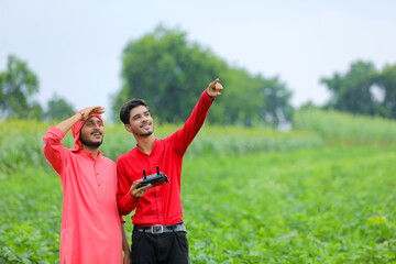 Naklejka premium Indian farmer and agronomist using drone at agriculture field