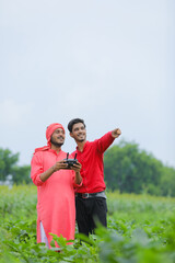 Indian farmer and agronomist using drone at agriculture field