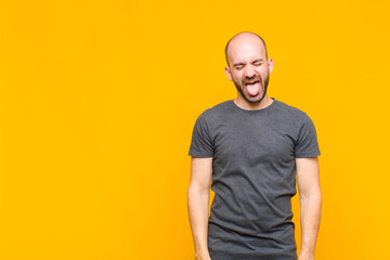 bald man with cheerful, carefree, rebellious attitude, joking and sticking tongue out, having fun