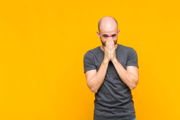 bald man feeling worried, hopeful and religious, praying faithfully with palms pressed, begging...