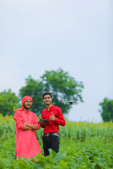 Indian farmer and agronomist using drone at agriculture field