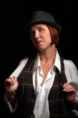 Portrait of ugle middle-aged woman with hat. Model posing in men's style in the Studio.
