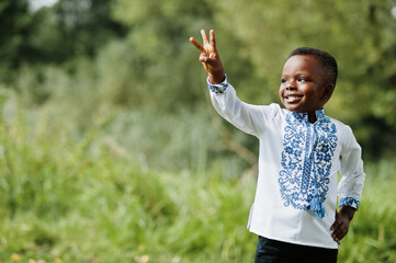 Portrait of african boy kid in traditional clothes at park.