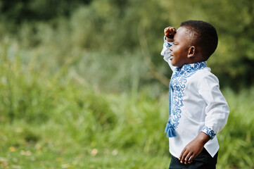 Portrait of african boy kid in traditional clothes at park.