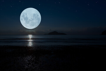 Full moon over the sea at night.