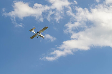 Russian private jet flies high. Flying a small white plane in the sky with clouds.