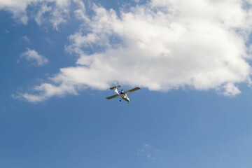 Fototapeta na wymiar Small plane flying in the blue sky