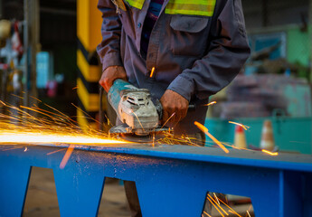 Man polishes metal with a grinding machine