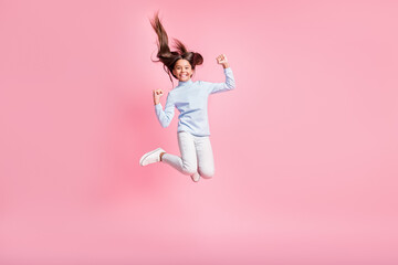 Full length body size view of pretty lucky cheerful girl jumping rejoicing having fun isolated over pink pastel color background