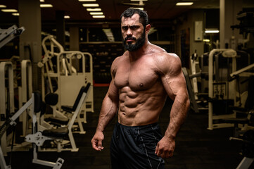 Fototapeta na wymiar strong young bearded male with sport physique in athlete fitness gym during training workout