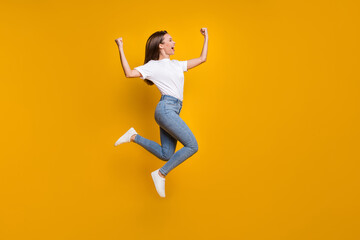 Fototapeta na wymiar Full length body size photo of cheerful happy girl fan jumping high gesturing like winner shouting isolated bright yellow color background